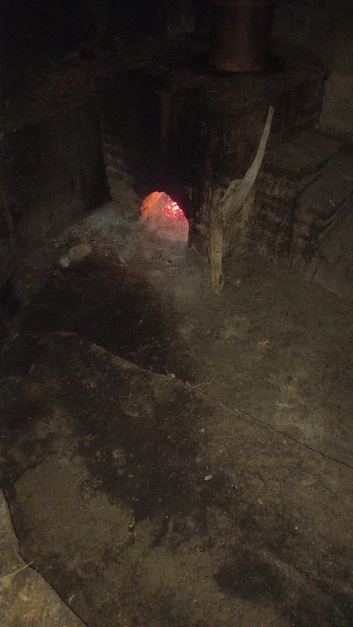 Fuego bajo la olla de cobre durante la destilación